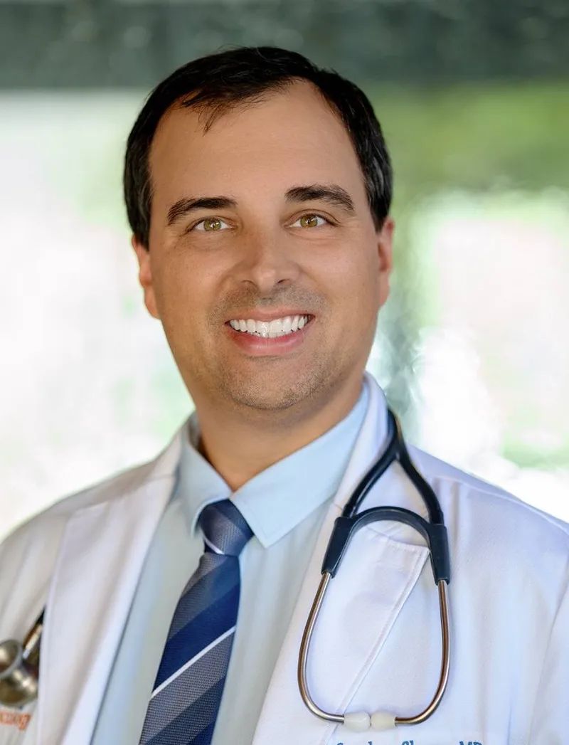 Dr. Stephen Shamp in a white coat, smiling