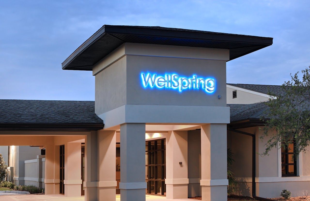 The entrance of the WellSpring Oncology building at dusk